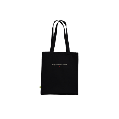 Back view of THE THREAD black tote showing the small reverse affirmation.