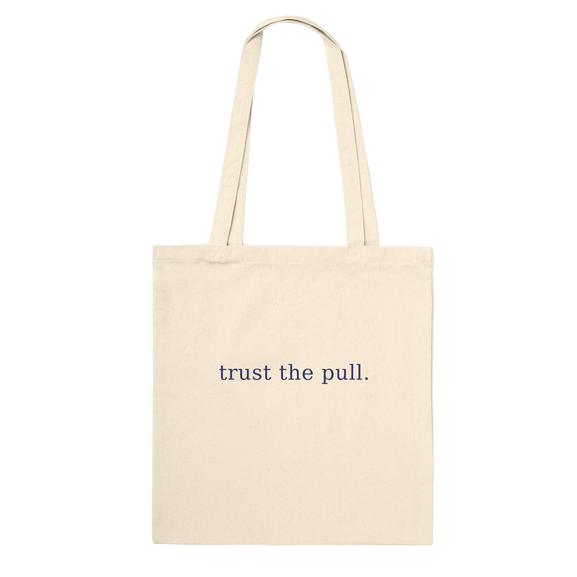 Rear view of THE PULL tote showing the words trust the pull on natural cotton.