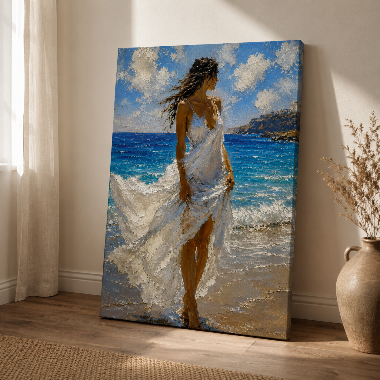 Windswept Mediterranean canvas art leaning against a wall in a sunlit room. The artwork depicts a woman in a flowing white dress standing at the edge of a bright blue ocean under a cloudy sky.
