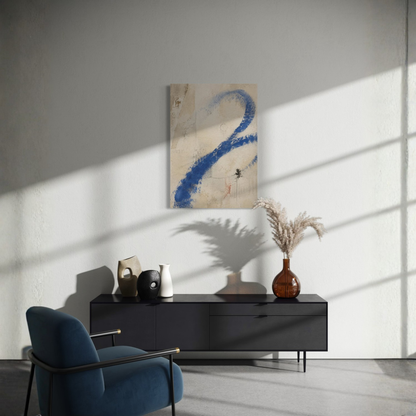 Proof of Life blue abstract wall art displayed above a dark sideboard with strong natural light and a blue chair.