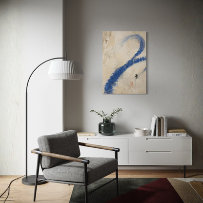 Proof of Life blue abstract canvas displayed above a white sideboard beside a dark armchair in a refined modern interior.