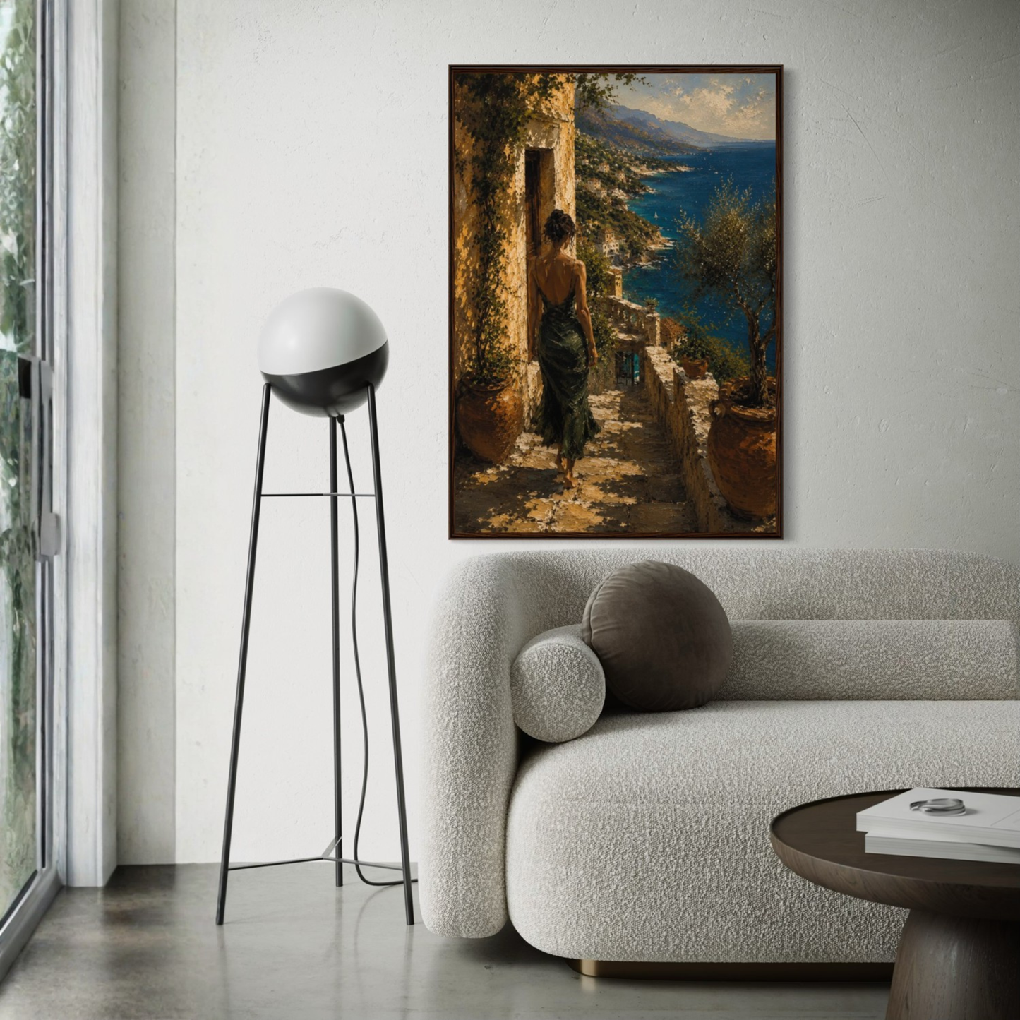 Framed Mediterranean wall art of a woman in a scenic setting above a modern living room sofa.