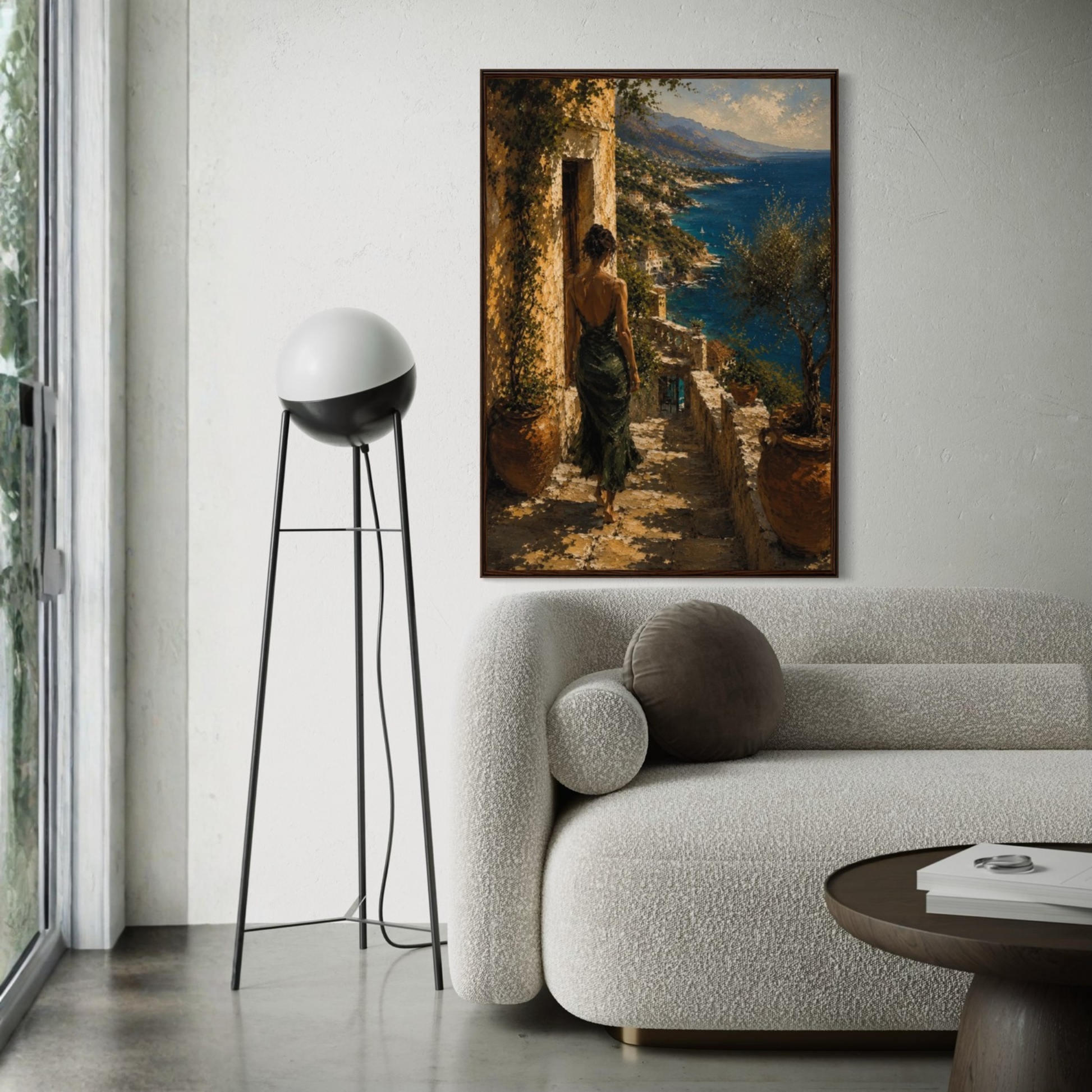 Framed Mediterranean wall art of a woman in a scenic setting above a modern living room sofa.