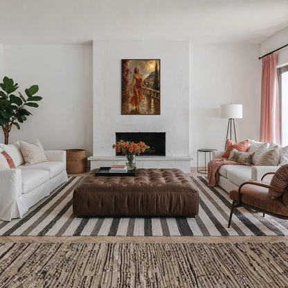 A styled living room interior featuring a large brown tufted leather ottoman centered on a black and white striped area rug. The room includes a white sofa on the left, a white sofa with pink pillows on the right, a brown armchair, a fireplace with The Sunshower Mediterranean framed art print displayed in a dark wood frame.