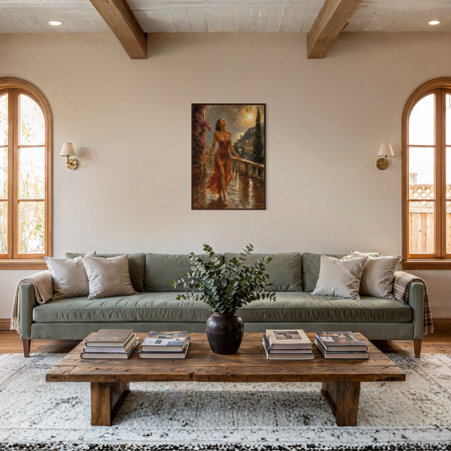A styled living room featuring a sage green fabric sofa with light beige throw pillows, a rustic wooden coffee table, and The Sunshower Mediterranean framed art print displayed in a dark wood frame hanging on the wall above the couch.