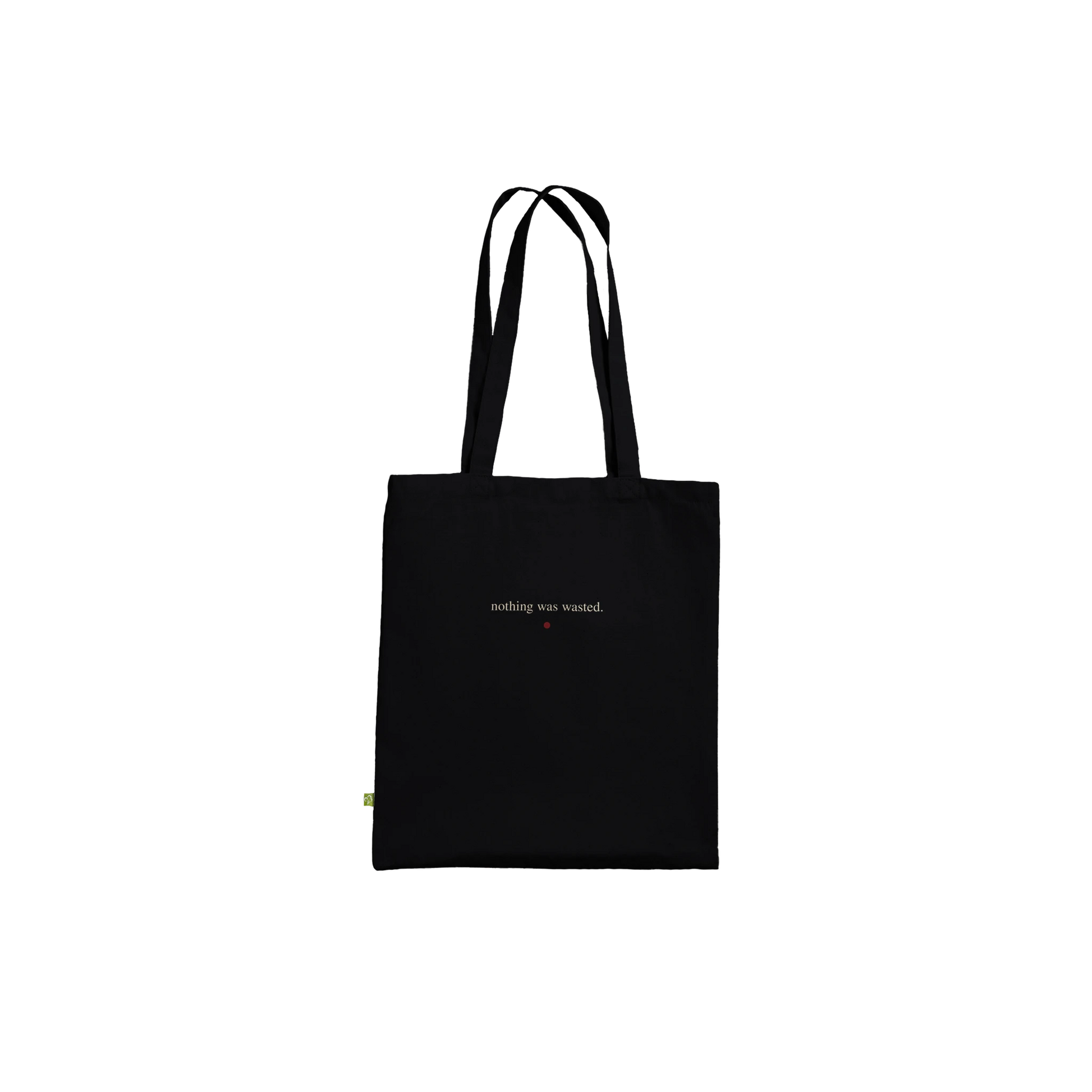 Reverse view of THE MENDING black cotton tote featuring the affirmation “nothing was wasted.