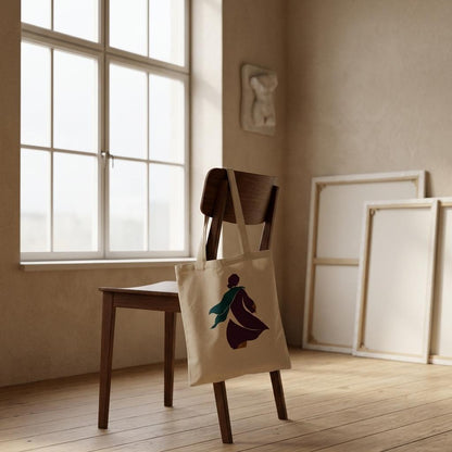 THE TURN natural cotton art tote displayed on a wooden chair in a calm neutral interior.